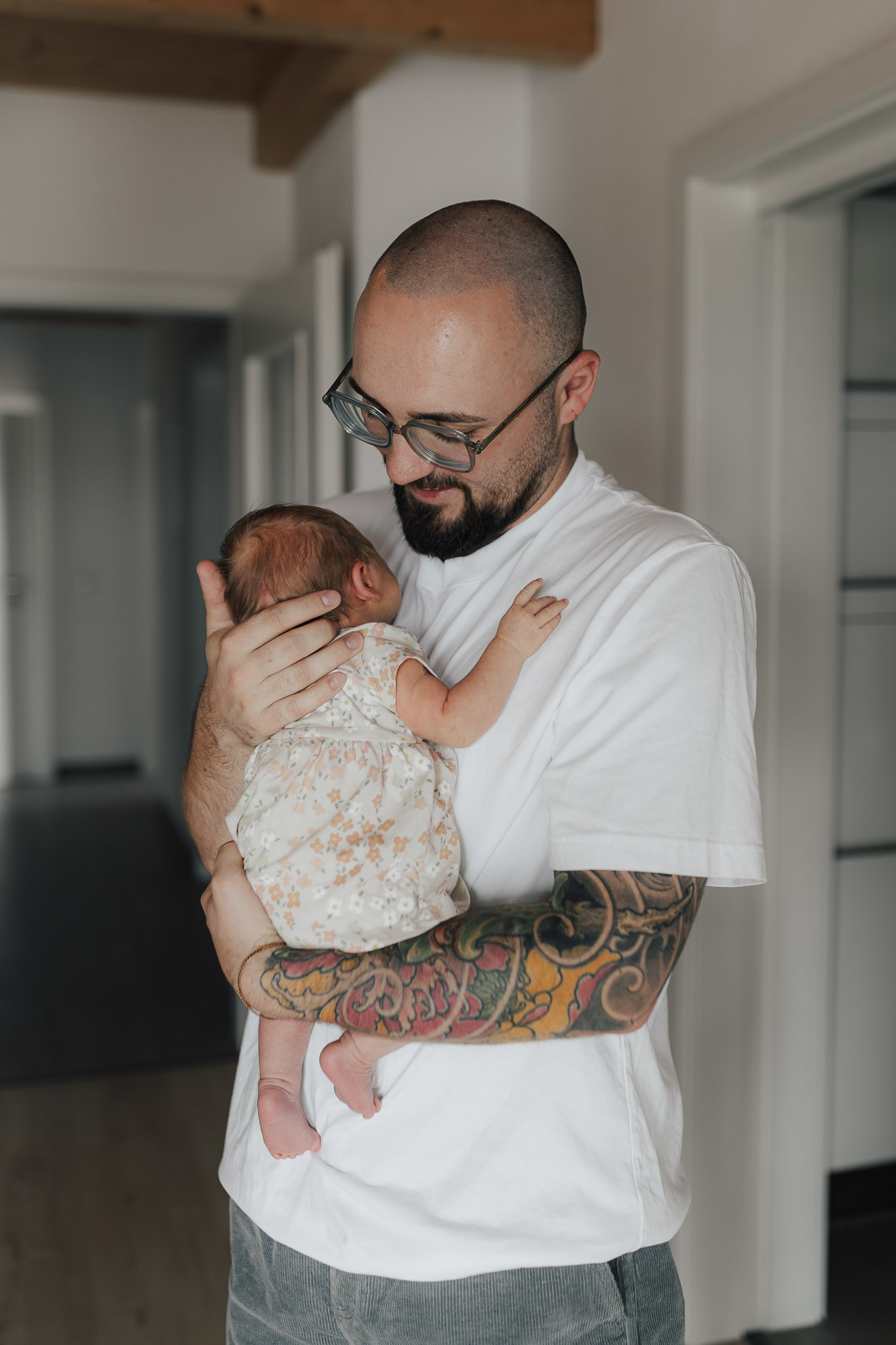 Mann hält Baby in den Armen, fotografiert von Ansichtssach Fotografie Maria Bruckmaier